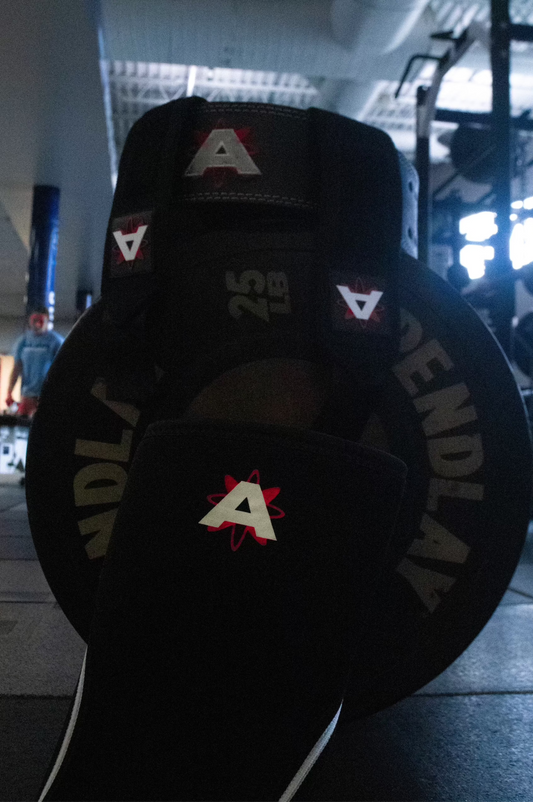 Weight plate with 'A' logo in a gym setting