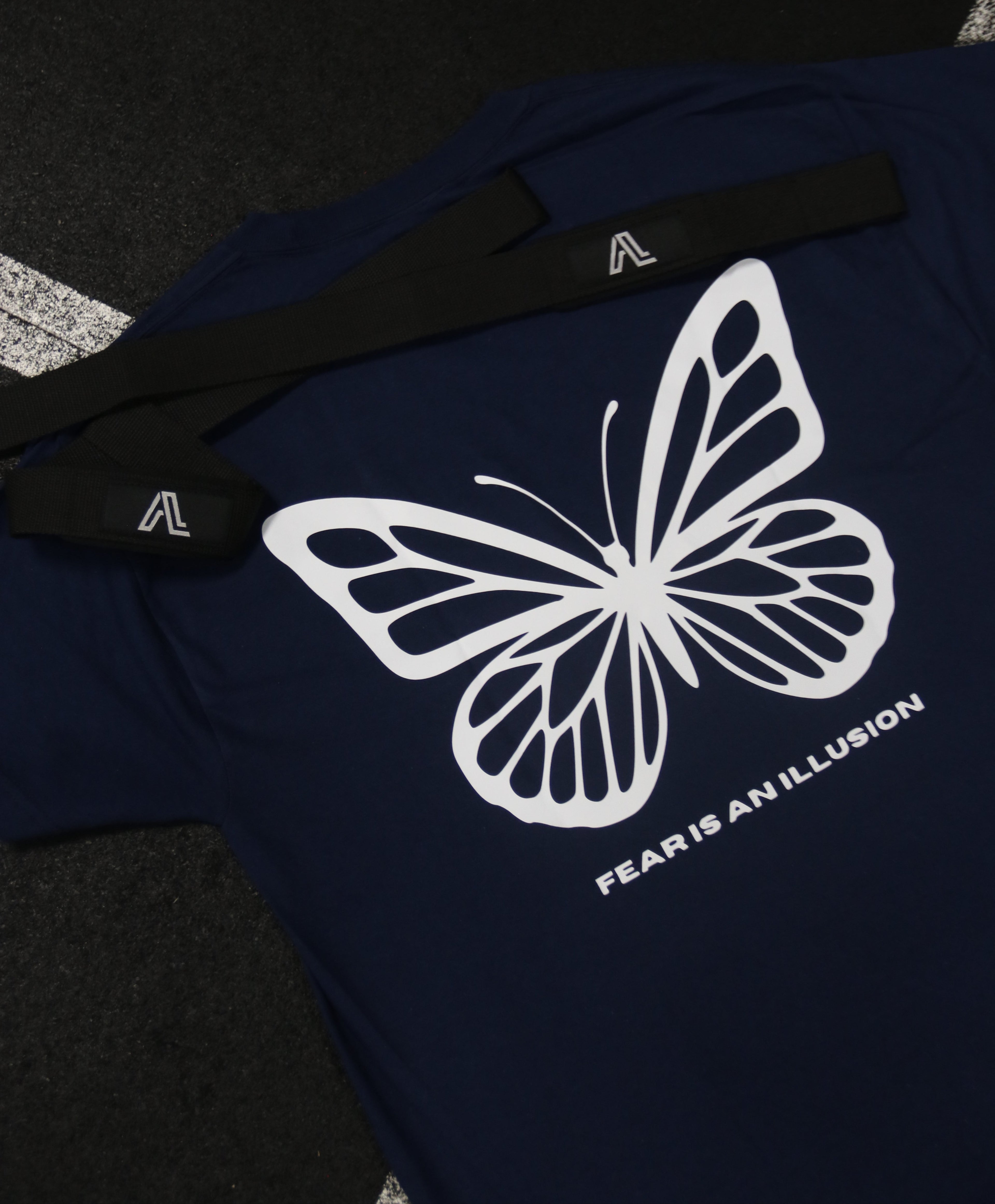 Navy blue shirt with a white butterfly logo on a dark background