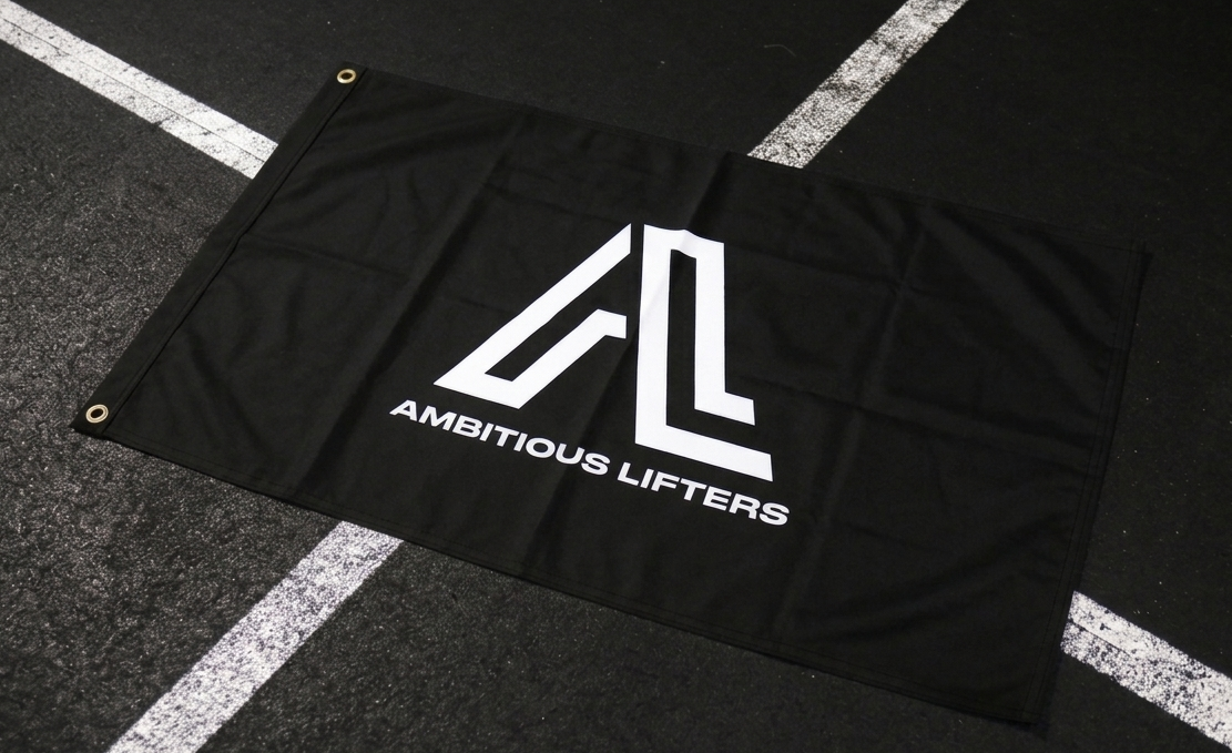 Black flag with 'Ambitious Lifters' logo on a black floor with white lines