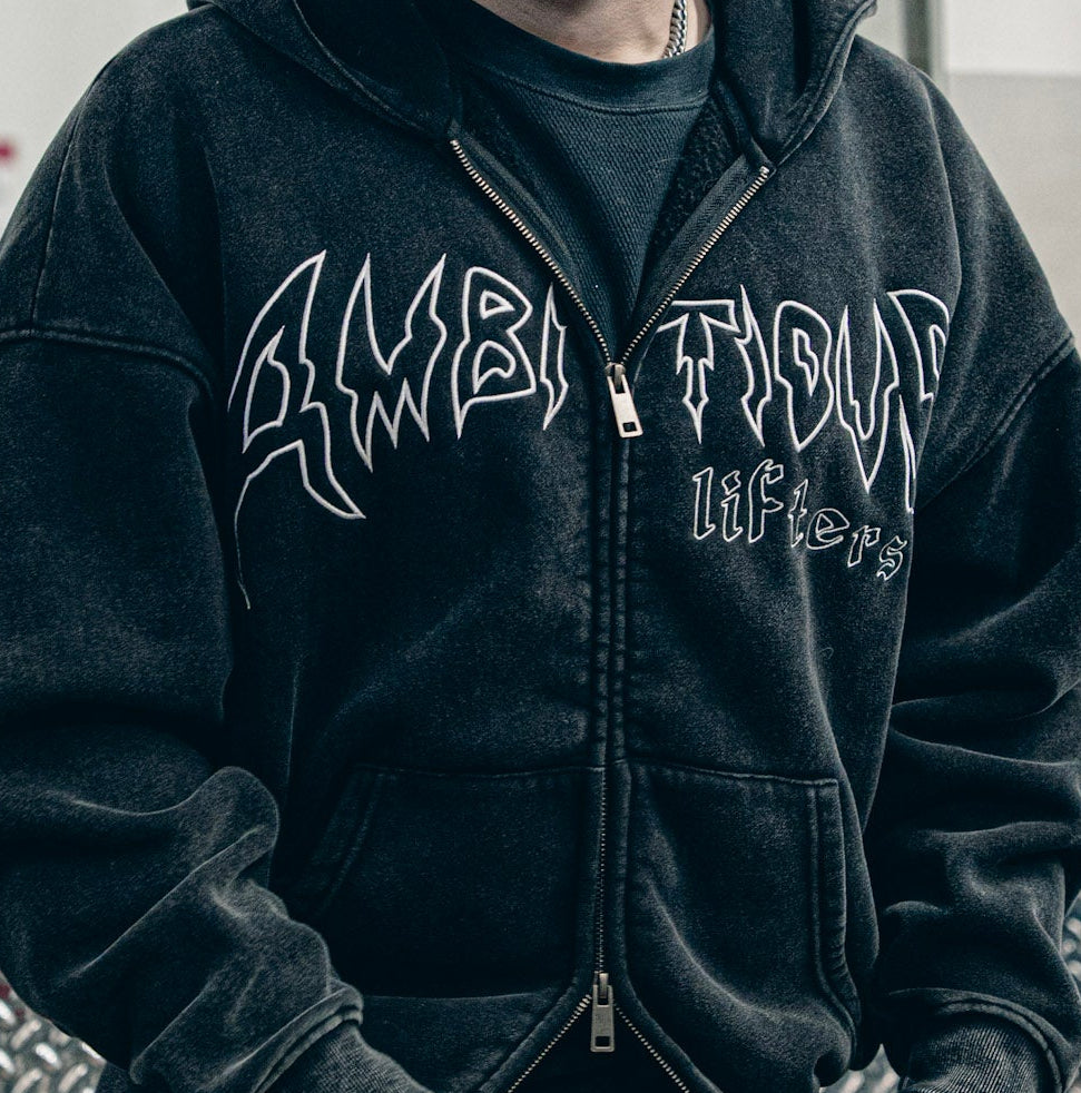 Person wearing a black hoodie with white text in an indoor setting