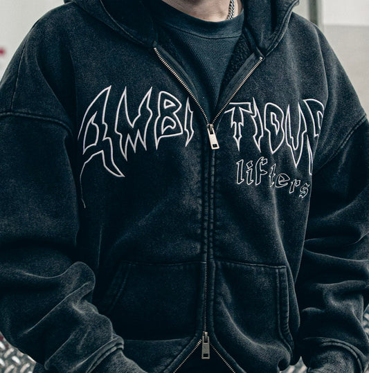 Person wearing a black hoodie with white text in an indoor setting